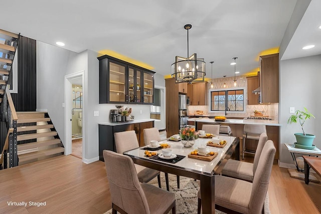 dining room with recessed lighting, stairway, light wood-style floors, baseboards, and a chandelier