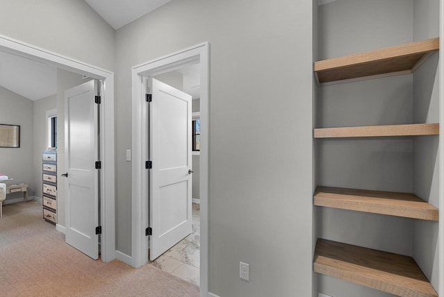 hallway featuring marble finish floor and baseboards