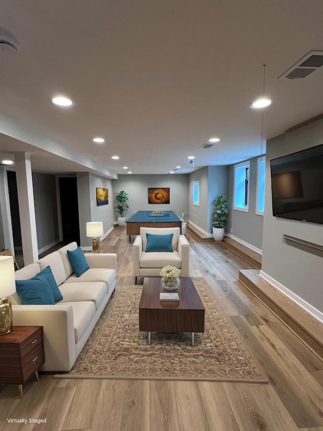 living room with recessed lighting, visible vents, baseboards, and wood finished floors