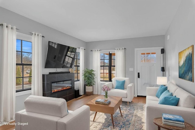 living room featuring a glass covered fireplace and wood finished floors