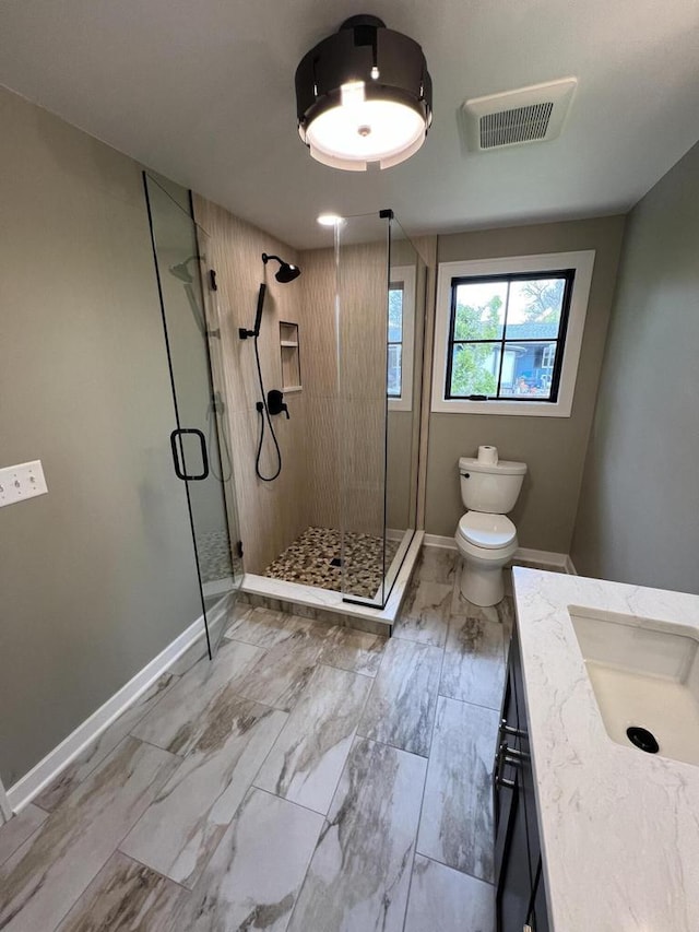 full bathroom with visible vents, toilet, a stall shower, baseboards, and vanity