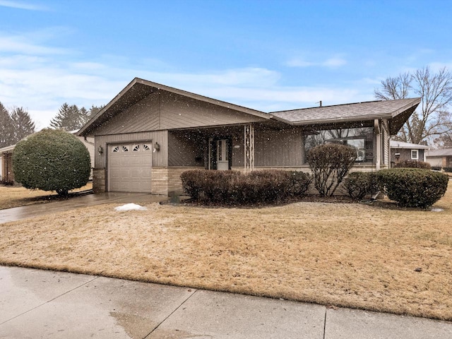 view of front of home featuring brick siding, an attached garage, and driveway