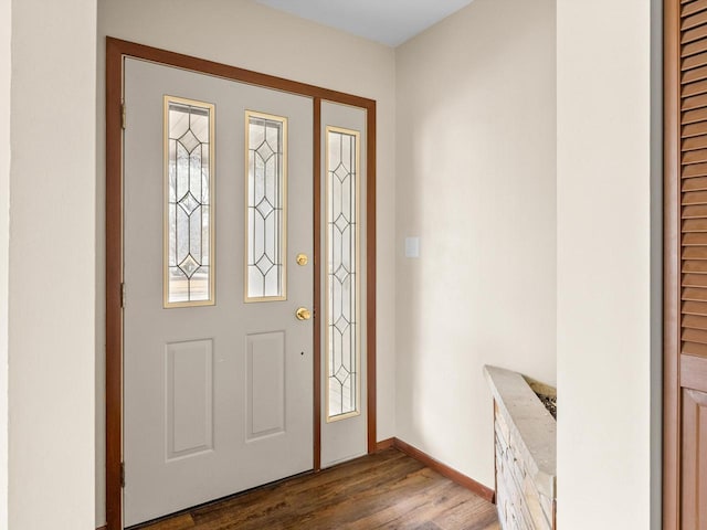 foyer with dark wood-style floors and baseboards