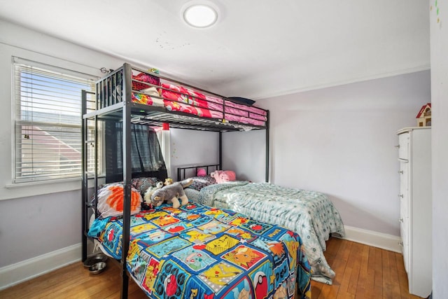 bedroom featuring baseboards and hardwood / wood-style flooring