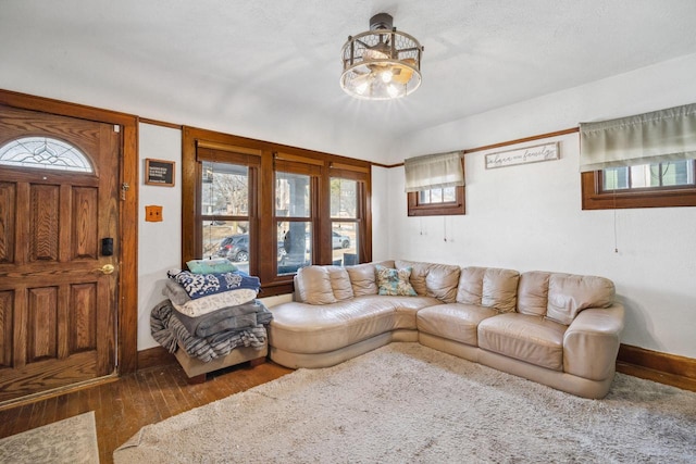 living area with baseboards and wood finished floors