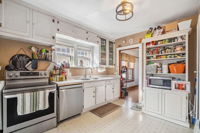 kitchen featuring a sink, light countertops, light floors, and stainless steel appliances