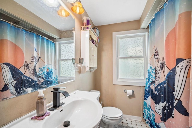 full bathroom with a shower with curtain, toilet, baseboards, and a sink