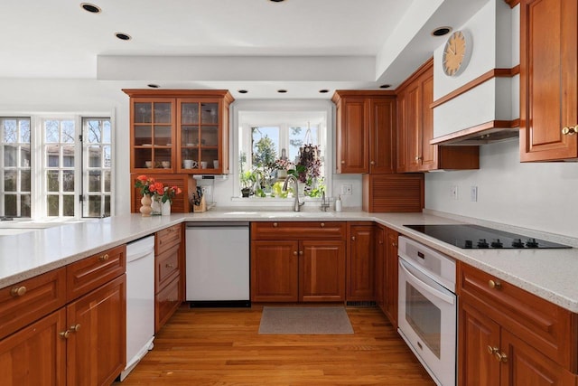 1914 Eastwood Ave, Janesville, WI 53545 - kitchen with white appliances, brown cabinetry, light wood-style flooring, plenty of natural light, and a sink