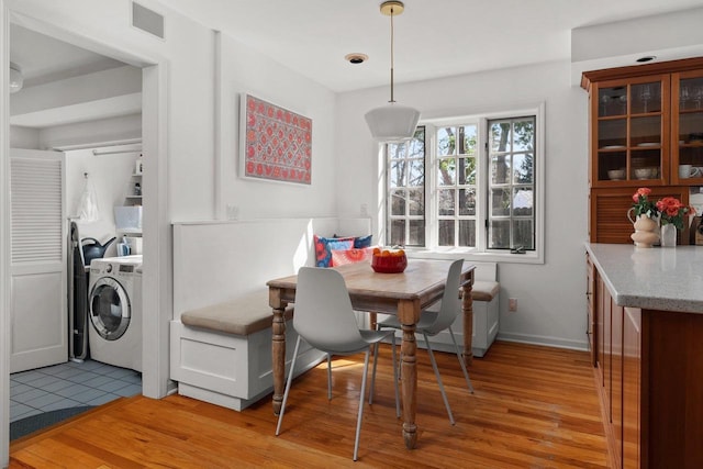 1914 Eastwood Ave, Janesville, WI 53545 - dining room featuring visible vents, baseboards, light wood-style flooring, washer / clothes dryer, and breakfast area