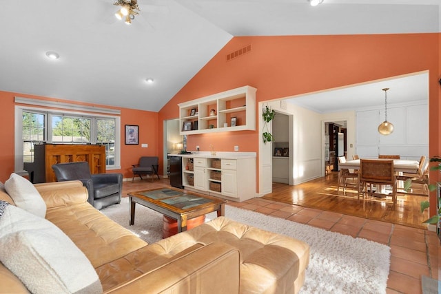 1914 Eastwood Ave, Janesville, WI 53545 - living room with visible vents, high vaulted ceiling, light tile patterned floors, baseboards, and indoor bar