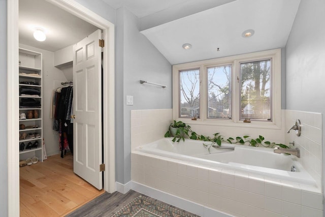 1914 Eastwood Ave, Janesville, WI 53545 - bathroom with a walk in closet, a garden tub, and wood finished floors