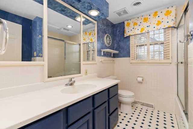 1914 Eastwood Ave, Janesville, WI 53545 - bathroom featuring tile walls, a shower with shower door, toilet, and visible vents