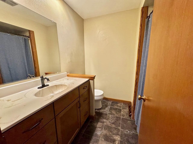 bathroom featuring visible vents, toilet, vanity, and baseboards