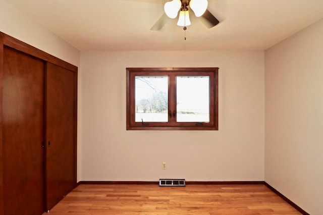 unfurnished bedroom with a closet, visible vents, light wood-type flooring, and baseboards