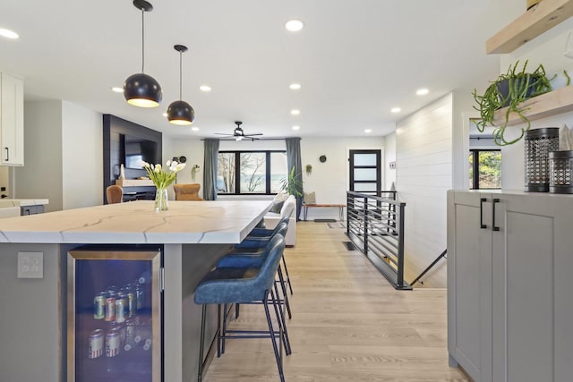 kitchen with wine cooler, plenty of natural light, recessed lighting, and light wood finished floors