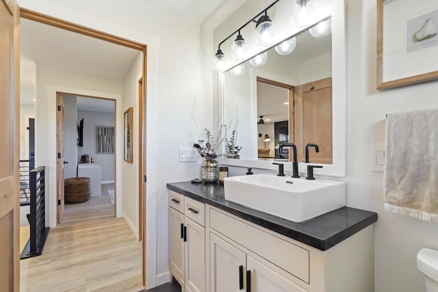 bathroom featuring vanity, toilet, and wood finished floors