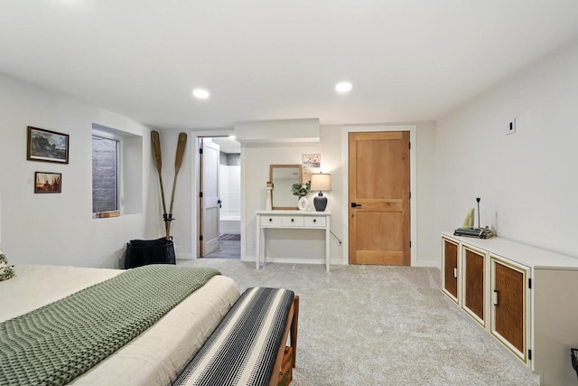 bedroom featuring recessed lighting, light colored carpet, baseboards, and ensuite bathroom