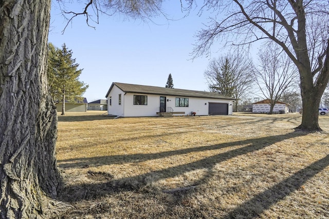 back of property featuring a yard, a garage, and driveway