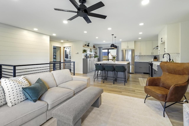 living area featuring light wood-style flooring, recessed lighting, and ceiling fan