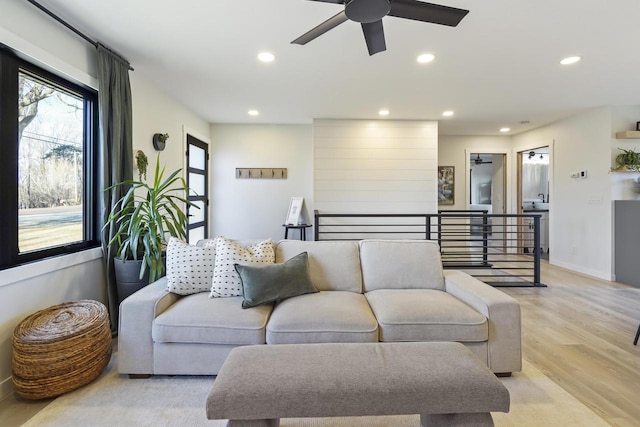 living room featuring recessed lighting, a ceiling fan, light wood-style flooring, and baseboards