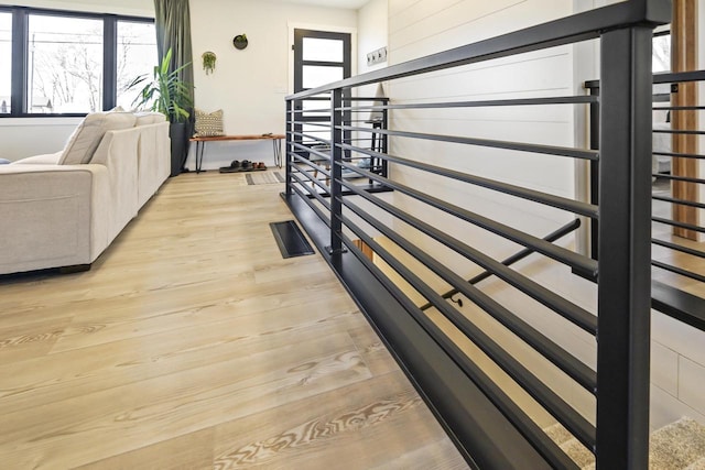 stairway with plenty of natural light and wood finished floors