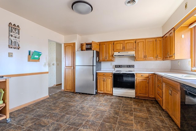 kitchen featuring electric stove, under cabinet range hood, a sink, freestanding refrigerator, and dishwasher