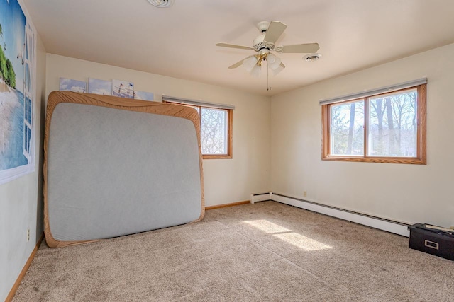 unfurnished bedroom featuring carpet, visible vents, baseboards, ceiling fan, and a baseboard heating unit