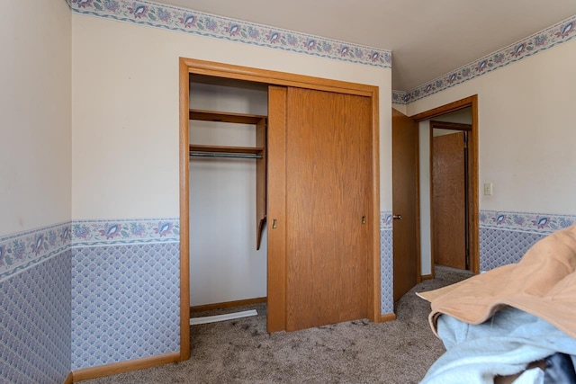 bedroom featuring carpet, a closet, and baseboards