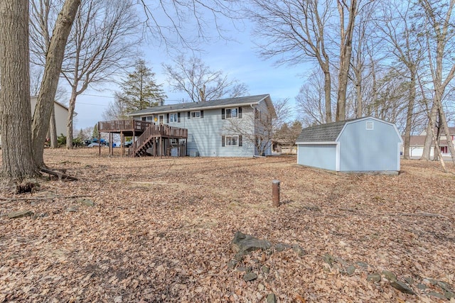 rear view of house featuring stairs, an outdoor structure, a wooden deck, and a storage shed