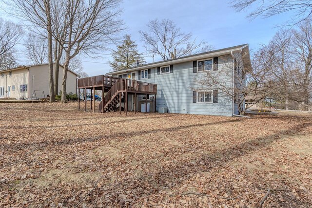 rear view of property featuring stairway and a deck