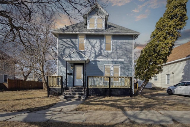 traditional style home with a deck and fence