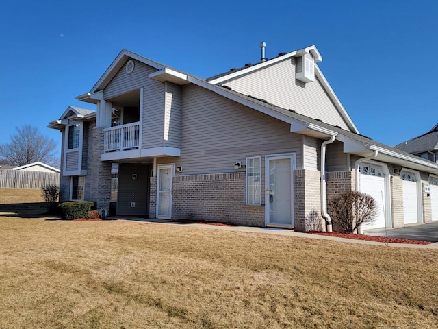 exterior space with a balcony, driveway, an attached garage, a front lawn, and brick siding