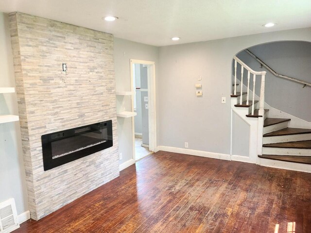 8630 W Lancaster Ave, Milwaukee, WI 53225 - unfurnished living room with a stone fireplace, wood finished floors, stairs, baseboards, and recessed lighting