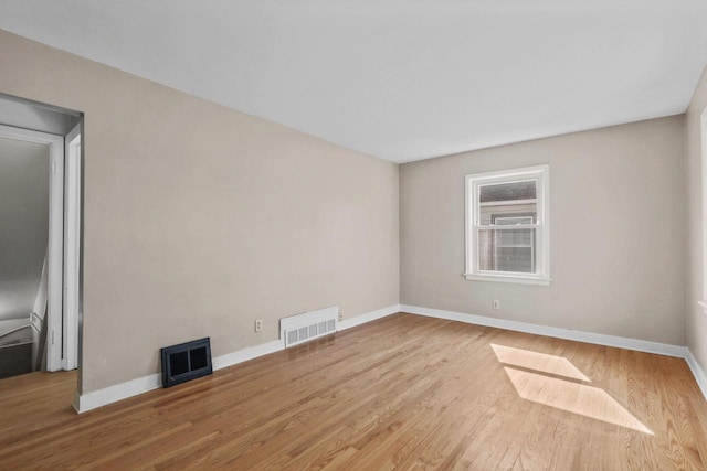 empty room with visible vents, baseboards, and wood finished floors