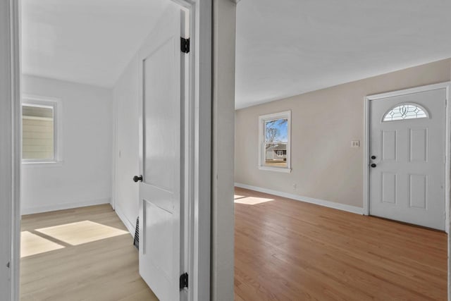 foyer featuring light wood finished floors and baseboards