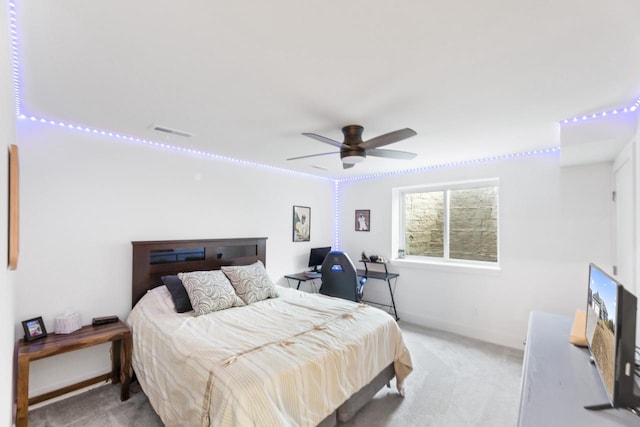 bedroom with a ceiling fan, baseboards, visible vents, and light carpet