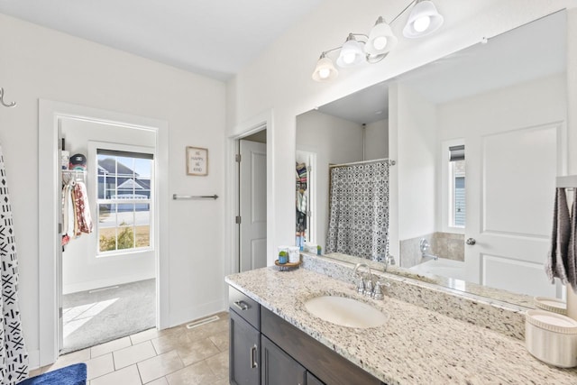 bathroom with vanity, a shower with shower curtain, visible vents, baseboards, and tile patterned floors