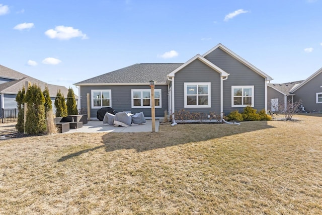 back of house with fence, roof with shingles, an outdoor living space, a patio area, and a lawn