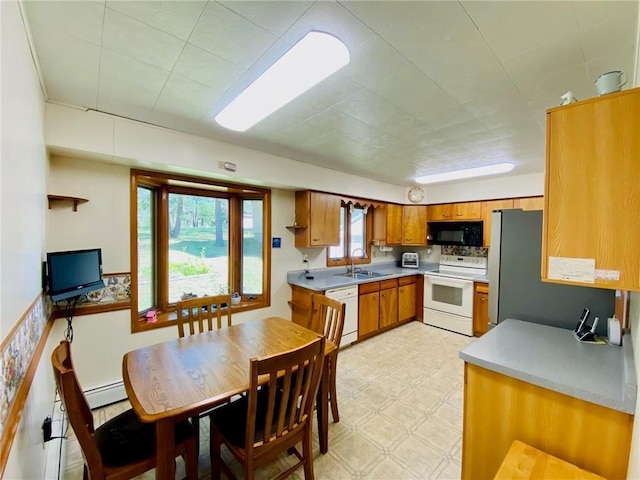 kitchen with light floors, light countertops, brown cabinets, white appliances, and a sink