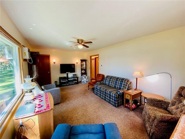 carpeted living area with ceiling fan