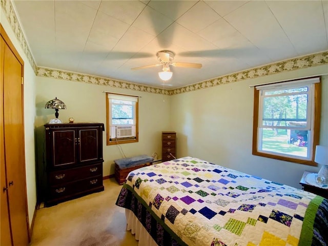 bedroom featuring light carpet, cooling unit, and ceiling fan