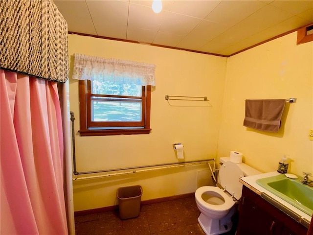 full bathroom featuring baseboards, toilet, vanity, and crown molding