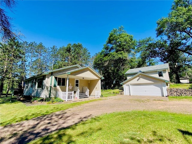 view of front of property with an outbuilding, dirt driveway, covered porch, a front yard, and a garage