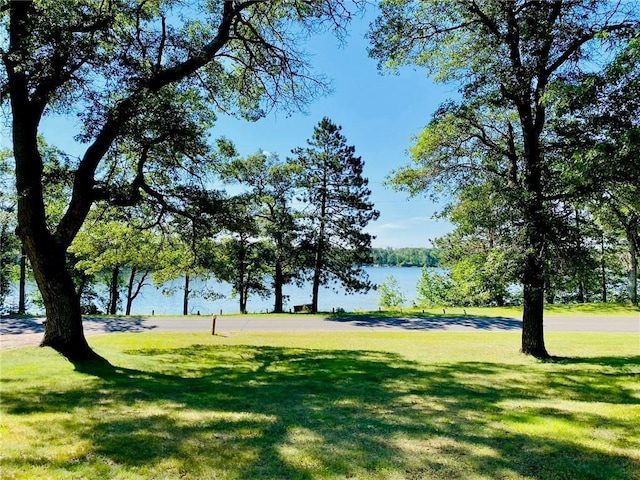 surrounding community featuring a lawn and a water view