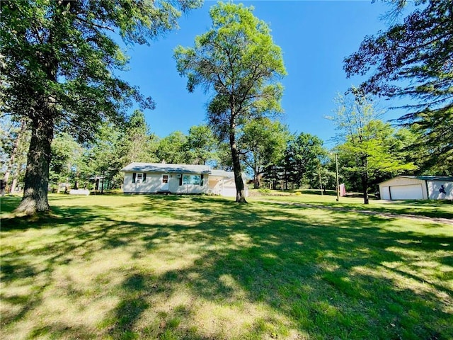 view of yard featuring a detached garage and an outdoor structure