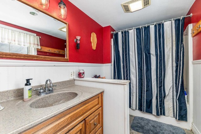 full bath with visible vents, wainscoting, vanity, and a shower with curtain