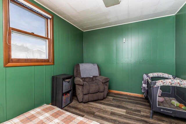 bedroom featuring ornamental molding and wood finished floors