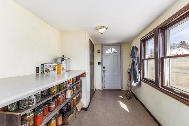 foyer with baseboards and light carpet