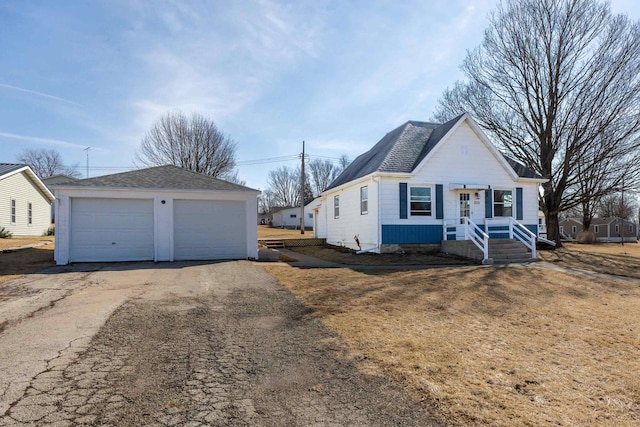 view of front of home with a garage, an outdoor structure, and roof with shingles