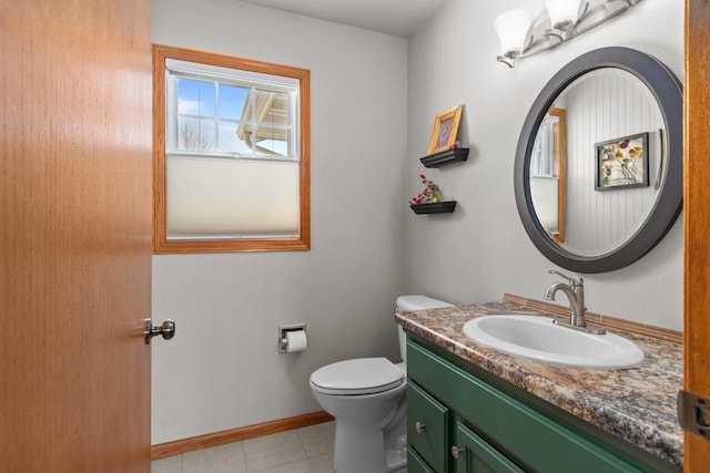 half bathroom with vanity, toilet, baseboards, and tile patterned flooring